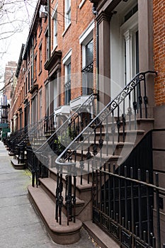 Stairs Leading to the Entrances of Old Brick Homes along a Sidewalk in Greenwich Village of New York City