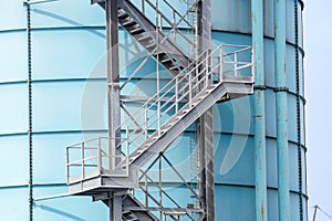 Stairs leading to the sky on a white industrial tank