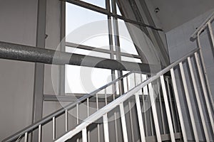 Stairs leading up, windows and pipes in an industrial building