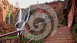 Stairs with a metal railing with a lantern leading up to a viewpoint on Ouzoud Falls near Ouzoud, Morocco.