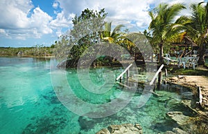 Stairs into seven colored lagoon surrounded by tropical plants in Bacalar, Quintana Roo, Mexico