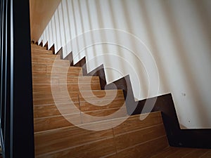 Stairs and the shadow of the banister... With wood-patterned ceramic textured doormats...