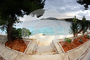 Stairs to the beach, clear water and cloudy sky in Croatia Dalmatia