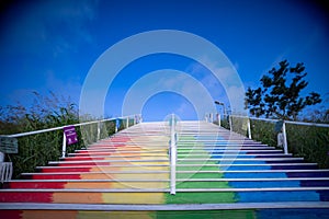 Stairs to heaven in rainbow colours and blue sky