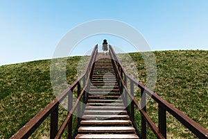 Stairs to heaven. Stairs into the future.Woman climbing wooden stairs at mountain