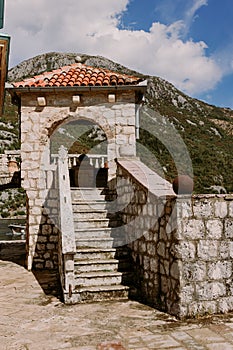Stairs to Roman catholic church our lady of the rocks on island islet in boka kotor bay near perast town in front of mountains ran