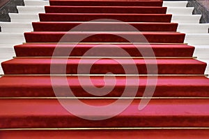 Stairs upwards covered with luxurious red carpet