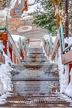 Stairway going down to a road on a hill with fresh white snow in winter