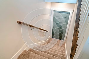 Stairway inside home with U shape design and leads to the wooden basement door