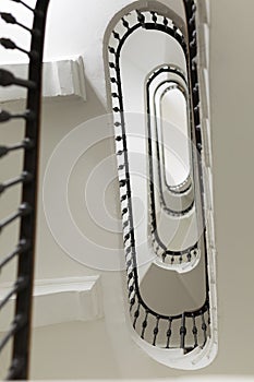 Stairwell from Below: White Oval Shape of Stairs in a Multi-storey Building