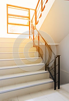 Stairwell fire escape in condominium, apartment or modern building with sun rays