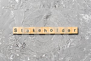 Stakeholder word written on wood block. Stakeholder text on cement table for your desing, concept