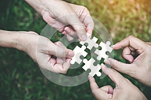 Stakeholders business team holding jigsaw puzzle as a team building and organization connection symbol. Teamwork and connection photo