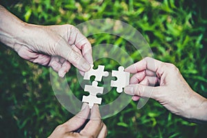 Stakeholders business team holding jigsaw puzzle as a team building and organization connection symbol. Teamwork and connection