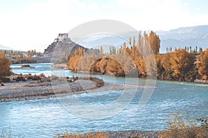 Stakna Gompa and Indus river before sunset with cloudy sky and mountains