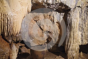 a stalactite in the cave with a pot