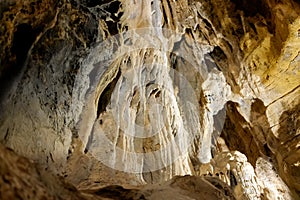 Stalactite and stalagmite formations on the rocky walls of a large underground cave