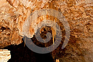 Stalactite and stalagmite formations on the wall of an undergrou