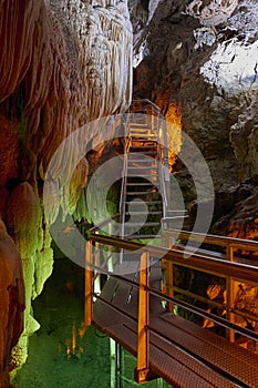 Stalactites hanging over a stairway in underground semi submersed cave