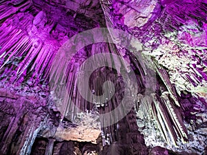Stalactites and stalagmites in St Michael`s Cave Gibraltar - magenta