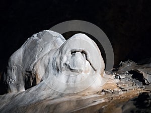 Stalagmite in a cave with ghost shape