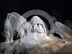 Stalagmite in a cave with ghost shape