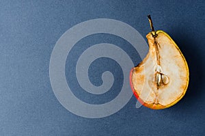 Stale old pear. Bite mark. Dark background