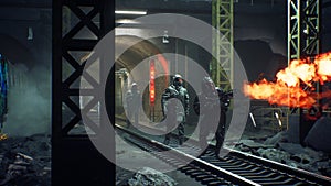 Stalkers in chemical protective clothing walk along an abandoned subway with a flamethrower during a virus epidemic. The photo
