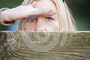 Stalking woman behind a fence hiding her face