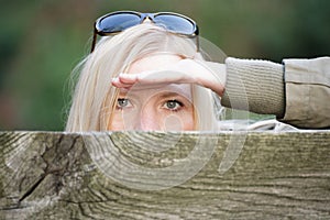 Stalking woman behind a fence hiding her face