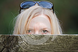 Stalking woman behind a fence hiding her face