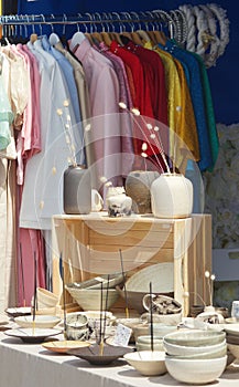 Stall with ceramics and clothing at street market.