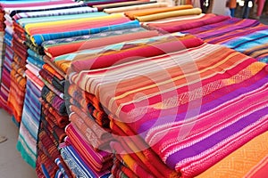 a stall featuring colorful handwoven rugs and mats