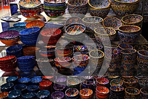 Stall in the Old Souk with mirrored shelves, full of pottery and colorful dishes, Dubai, UAE