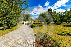 A beautiful, colorful city park with an artificial river, a fountain and walking people on a photo