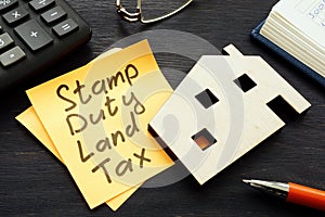 Stamp duty land tax SDLT memo and model of home. photo