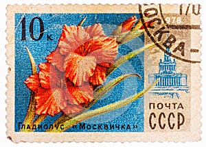 Stamp printed in USSR CCCP, soviet union shows image of gladiolus Moscovite and VDNH building from Moscow