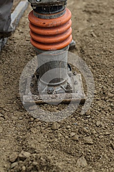 Stamping soil with rammer tool