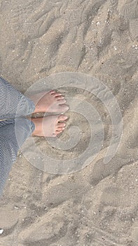 Stand barefoot on the sand on the beach.