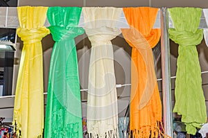 On the stand bright women`s scarves tied knot