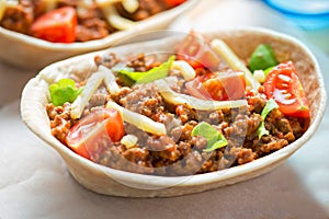 Stand n stuff tortillas with minced beed, tomatoes, lettuce and cheddar