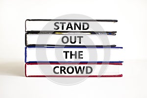 Stand out the crowd symbol. Concept words Stand out the crowd on books on a beautiful white table white background. Business,
