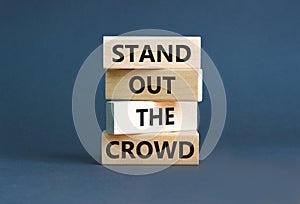 Stand out the crowd symbol. Concept words Stand out the crowd on wooden blocks on beautiful grey table grey background. Business,