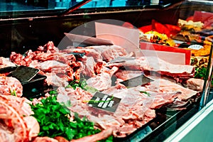 Stand with raw meat in supermarket store