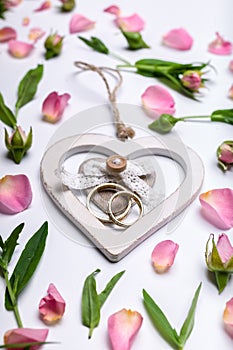 Stand for rings in the shape of a heart. Flower pattern on a white background. Petals and rosebuds. Vertical shot