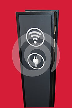 Stand tower for charging mobile phones in shopping Mall, wifi zone sign isolated on red background by clipping, vertical shot
