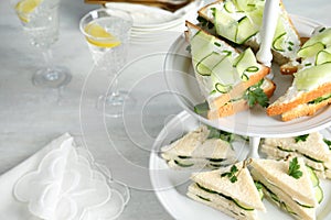 Stand with traditional English cucumber sandwiches on table.