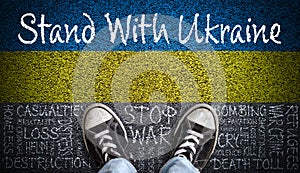 Stand With Ukraine Message on Asphalt With Painted Flag and Stop War Word Cloud