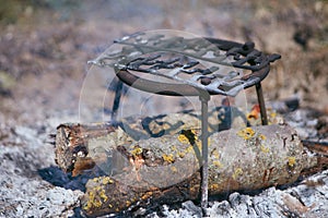 Stand for the kettle and smoldering fire with large logs