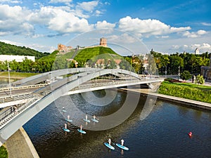 Stand up paddle boarders passing by Gediminas Tower, the remaining part of the Upper Castle in Vilnius. SUP getting popular in